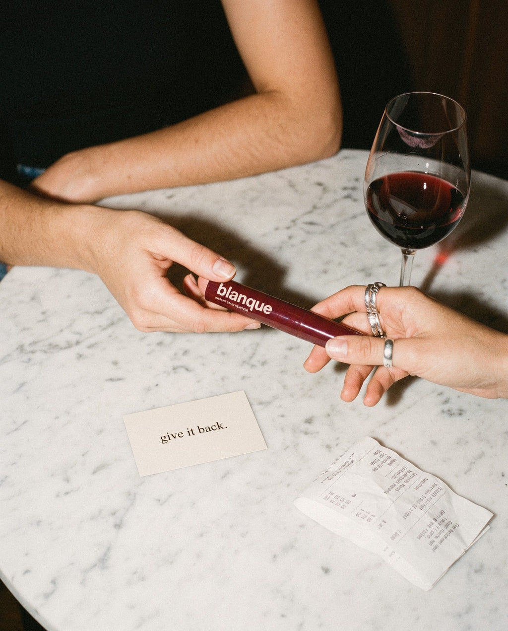 Passing the blanque pen across a marble table, the card says give it back.