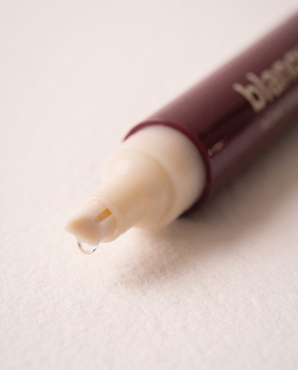 The frosted chisel tip with a bead of liquid at its edge.