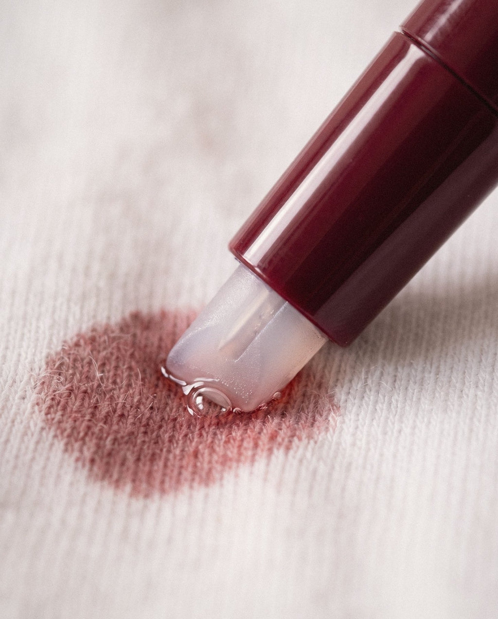 The chisel tip pressed on a small red-wine stain on white cotton.