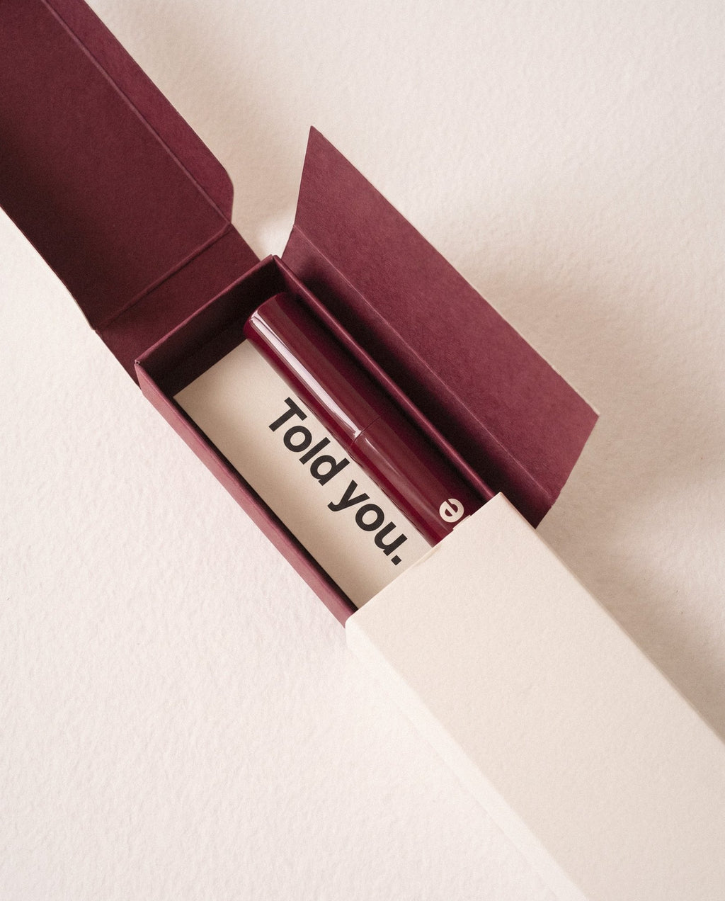 The box open: a bordeaux inside and a small card that says Told you.
