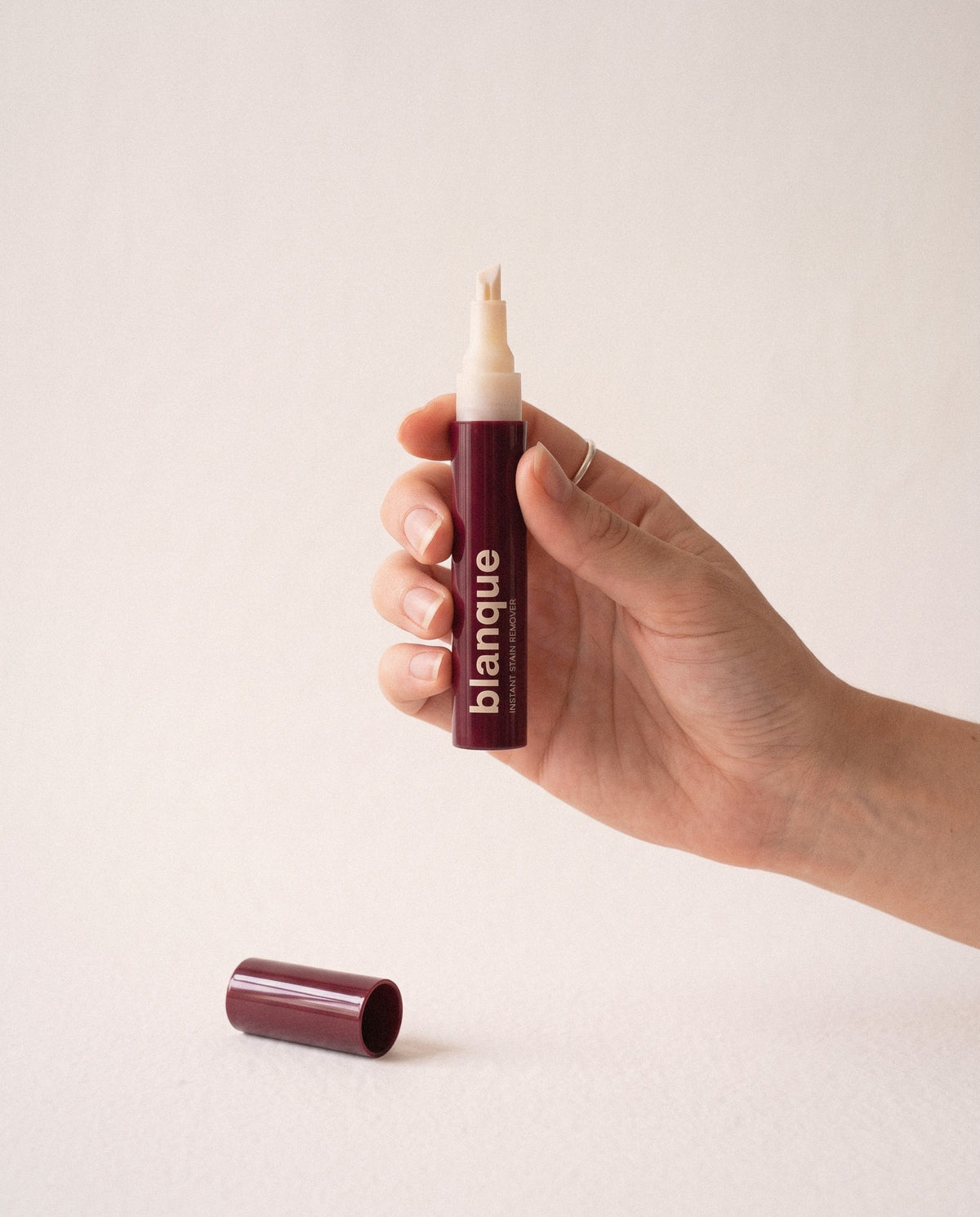 The pen held between two fingers like a lipstick, chisel tip up.